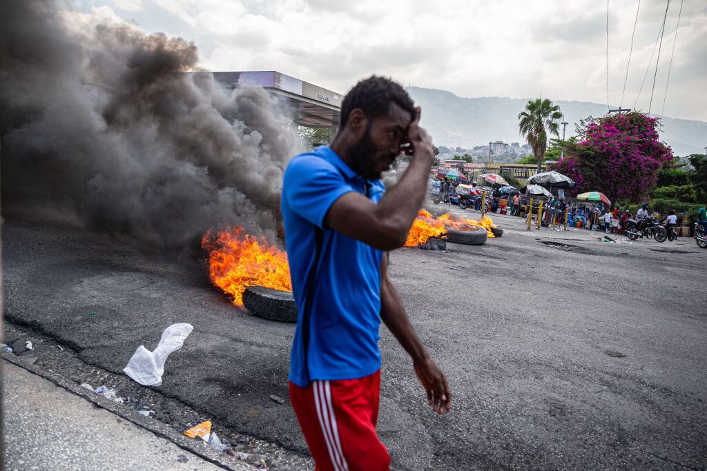 Un hombre camina en medio de las barricadas en las calles de la ciudad de Puerto Príncipe en Haití.