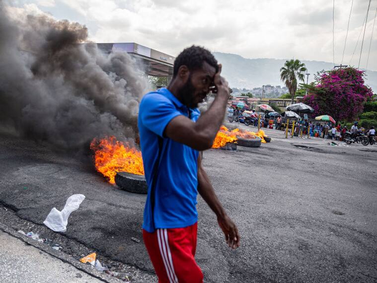 Un hombre camina en medio de las barricadas en las calles de la ciudad de Puerto Príncipe en Haití.