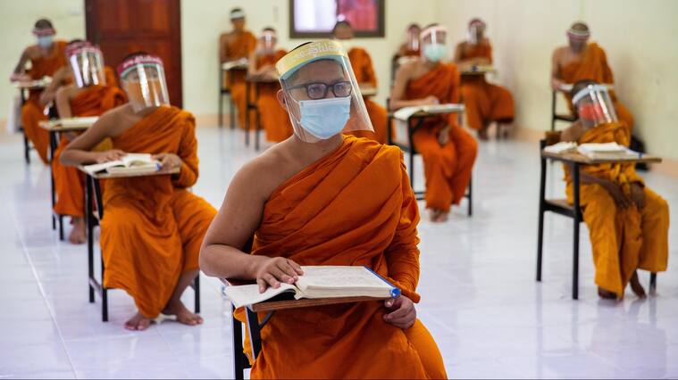 BANGKOK, THAILAND - APRIL 17: Thai Monks wear face maks and face shields to protect themselves from the coronavirus during their Pali language course at Wat Molilokkayaramon April 17, 2020 in Bangkok, Thailand. Though many Thai Monks in Bangkok left the city to wait out the coroavirus pandemic, Wat Molilokkayaram continues to house and teach over 200 monks. Social distancing measures and personal protective equipment has been given to each novice and monk to ensure their safety during their lessons and shared living conditions. Thailand is in a state of partial lockdown following the spread of Covid-19, with 2,700 confirmed cases of the virus. (Photo by Lauren DeCicca/Getty Images)