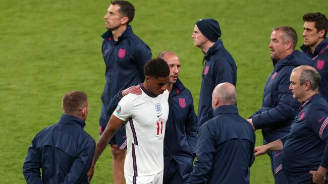 LONDON, ENGLAND - JULY 11: Marcus Rashford of England surround by the England coaching staff after the penalty shootout during the UEFA Euro 2020 Championship Final between Italy and England at Wembley Stadium on July 11, 2021 in London, United Kingdom. (Photo by Marc Atkins/Getty Images)