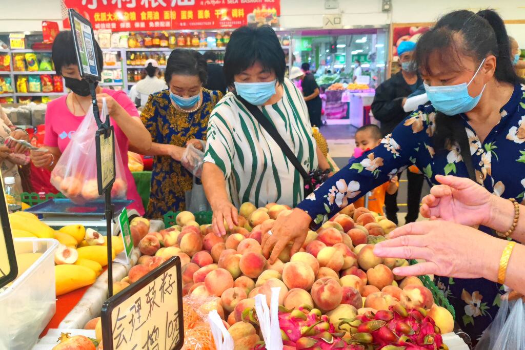 Personas compran alimentos en un supermercado de Pekín