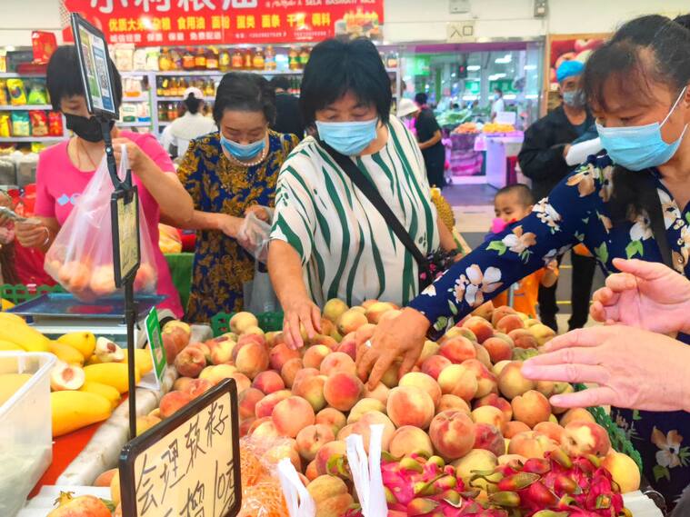 Personas compran alimentos en un supermercado de Pekín