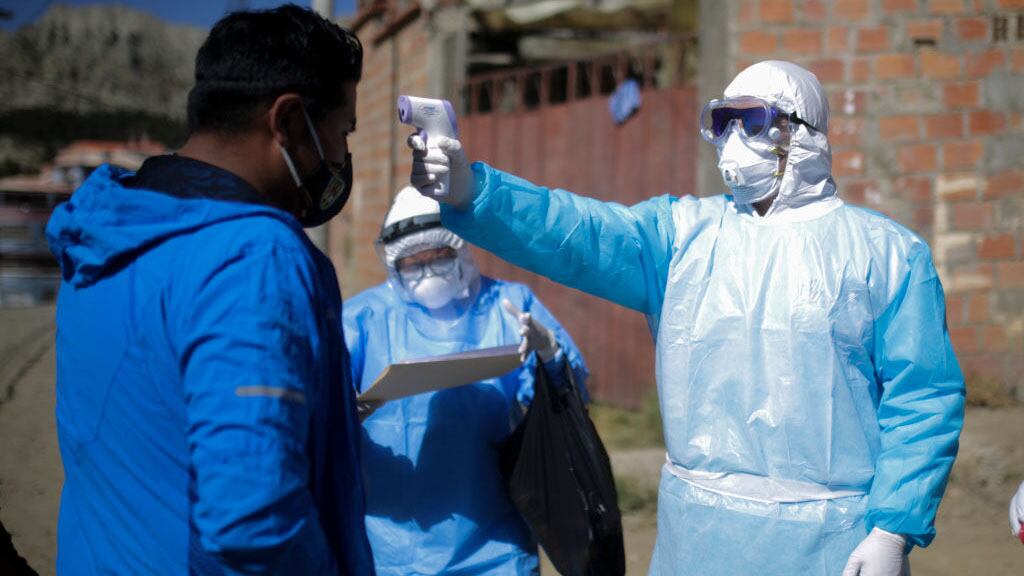 LA PAZ, BOLIVIA - JULY 12: A health worker measures the temperature to a man during an operation to identify COVID-19 cases amid the Coronavirus pandemic on July 12, 2020 in La Paz, Bolivia. According to the World Health Organization, Bolivia has over 47,000 positive cases of COVID-19 and more than 1700 deaths. (Photo by Gaston Brito/Getty Images)