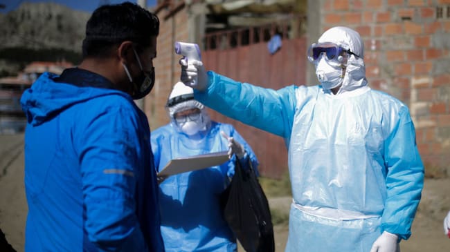 LA PAZ, BOLIVIA - JULY 12: A health worker measures the temperature to a man during an operation to identify COVID-19 cases amid the Coronavirus pandemic on July 12, 2020 in La Paz, Bolivia. According to the World Health Organization, Bolivia has over 47,000 positive cases of COVID-19 and more than 1700 deaths. (Photo by Gaston Brito/Getty Images)