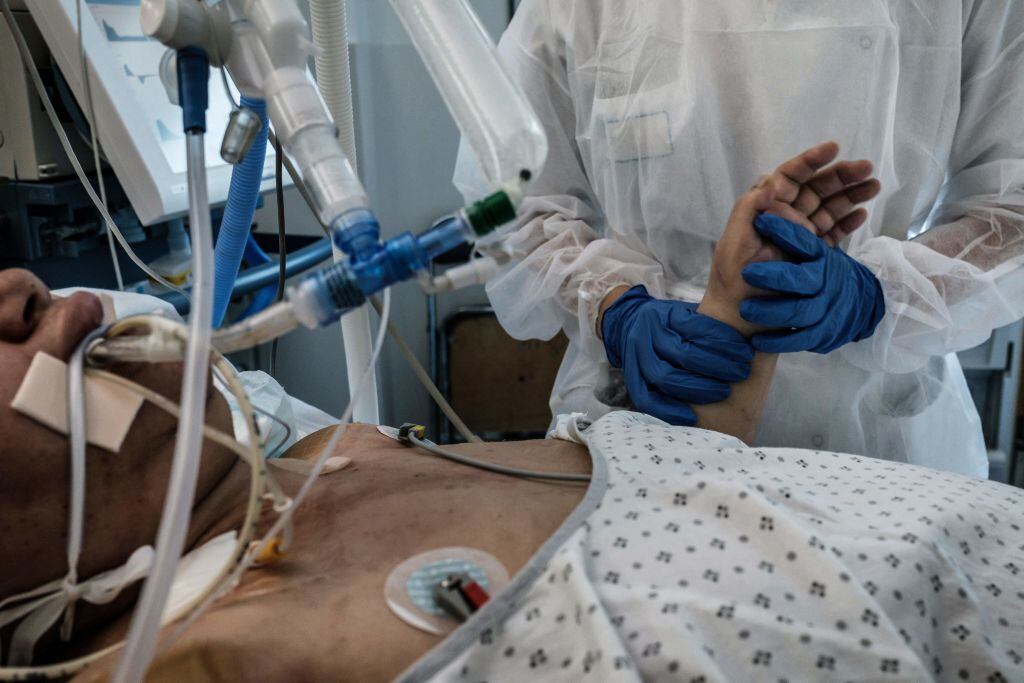Enfermera ayuda a paciente con Covid-19 en un hospital de Pierre-Benite