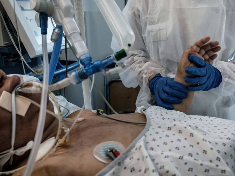 Enfermera ayuda a paciente con Covid-19 en un hospital de Pierre-Benite