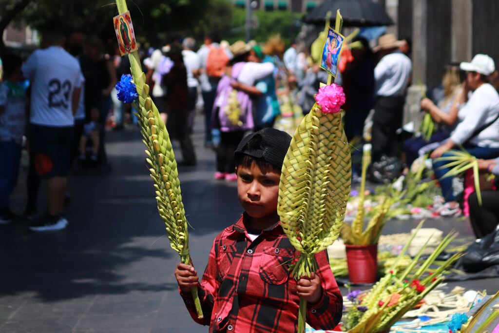 Niño vende mercancía religiosa junto a la catedral de Ciudad de México