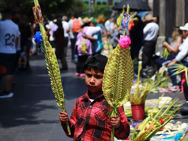 Niño vende mercancía religiosa junto a la catedral de Ciudad de México