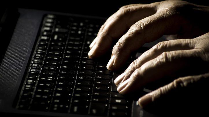 Danger concept on the internet, man's palms on a laptop keyboard