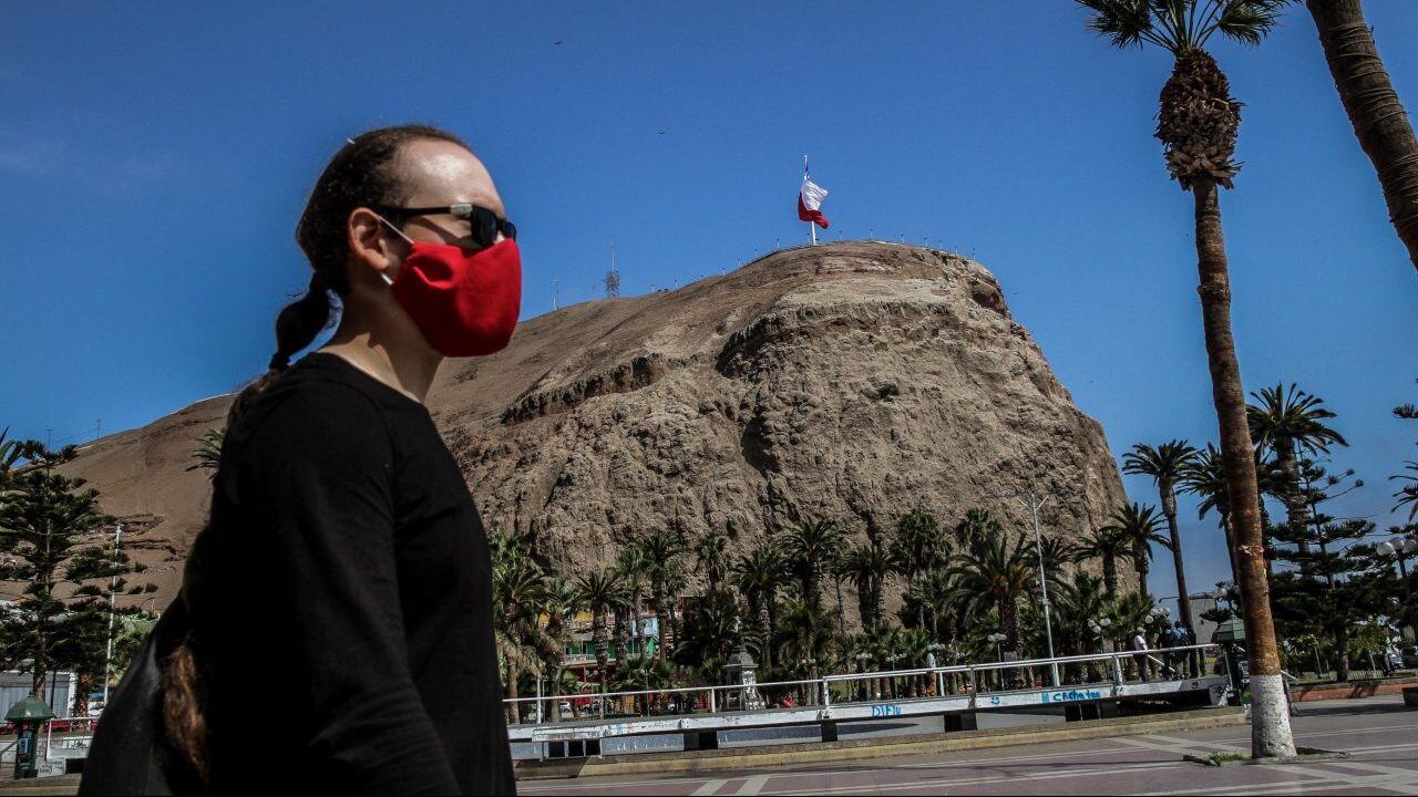 06 JULIO 2020 / ARICA Una mujer portando mascarilla transita por calle San Marcos, de fondo Morro Arica en medio de la pandemia por Coronavirus. FOTO: ALEXIS FUENTES / AGENCIAUNO