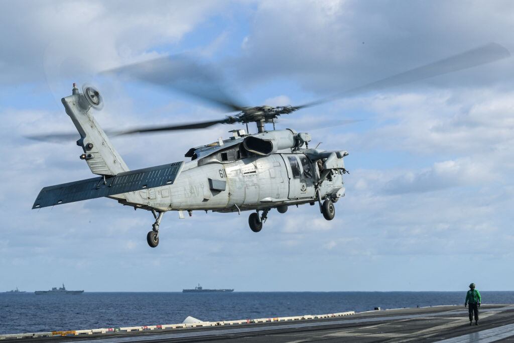 Un helicóptero de combate de las fuerzas armadas de Estados Unidos despega desde un portaaviones.