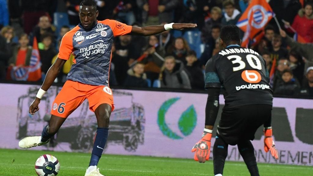 Montpellier's French defender Junior Sambia (L) kicks the ball in front of Marseille's French goalkeeper Steve Mandanda during the French L1 football match between Montpellier and Marseille at the Mosson stadium in Montpellier, southern France on November 4, 2018. (Photo by PASCAL GUYOT / AFP)        (Photo credit should read PASCAL GUYOT/AFP via Getty Images)