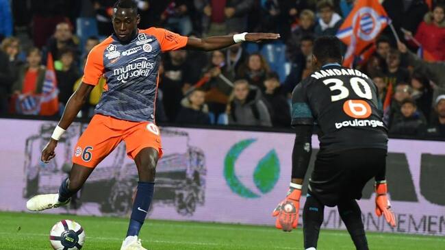 Montpellier's French defender Junior Sambia (L) kicks the ball in front of Marseille's French goalkeeper Steve Mandanda during the French L1 football match between Montpellier and Marseille at the Mosson stadium in Montpellier, southern France on November 4, 2018. (Photo by PASCAL GUYOT / AFP) (Photo credit should read PASCAL GUYOT/AFP via Getty Images)