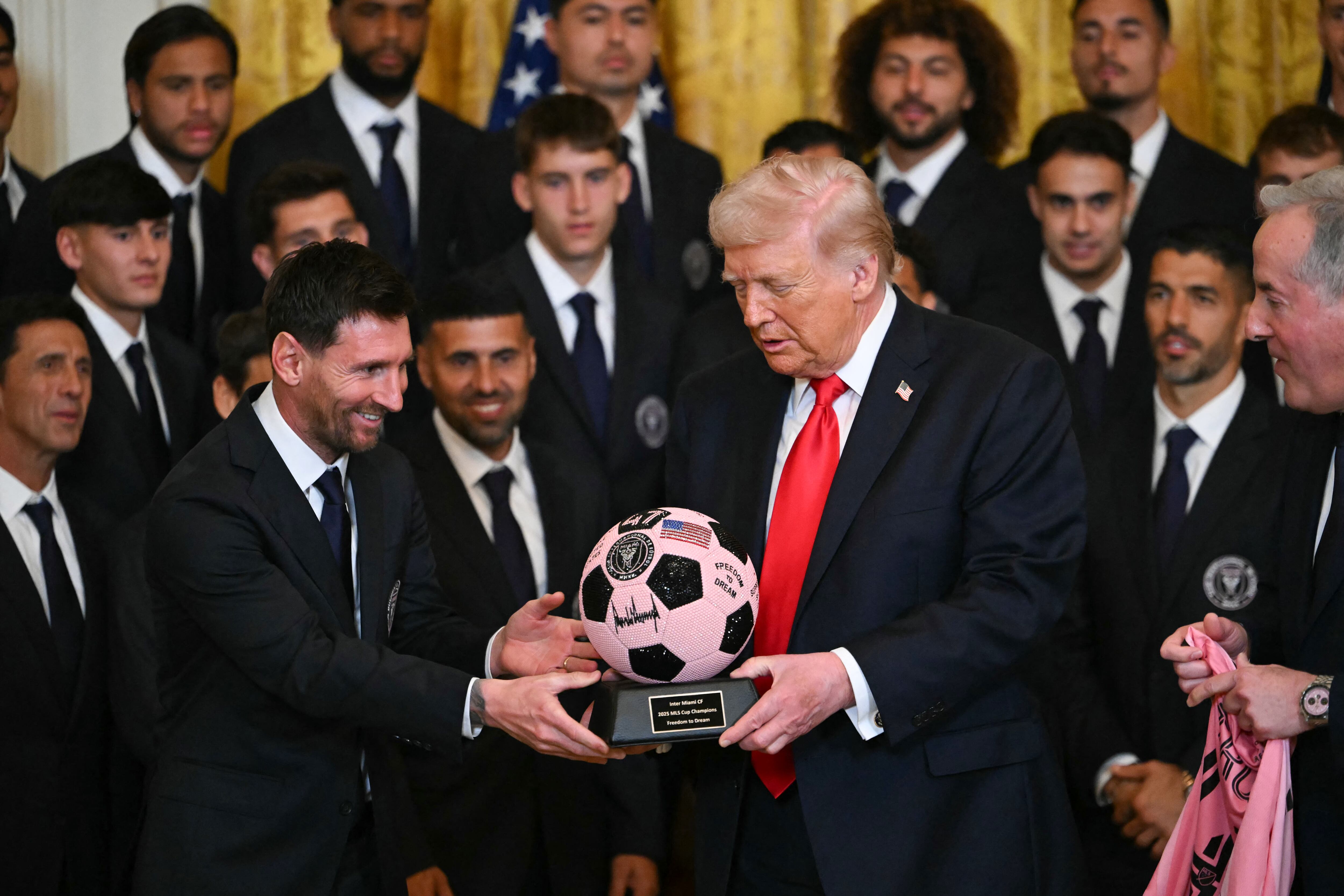 Argntinian star Lionel Messi hands US President Donald Trump a ball during an event for Inter Miami CF, winners of the 2025 Major League Soccer Cup, in the East Room of the White House in Washington, DC, on March 5, 2026. (Photo by ANDREW CABALLERO-REYNOLDS / AFP via Getty Images)