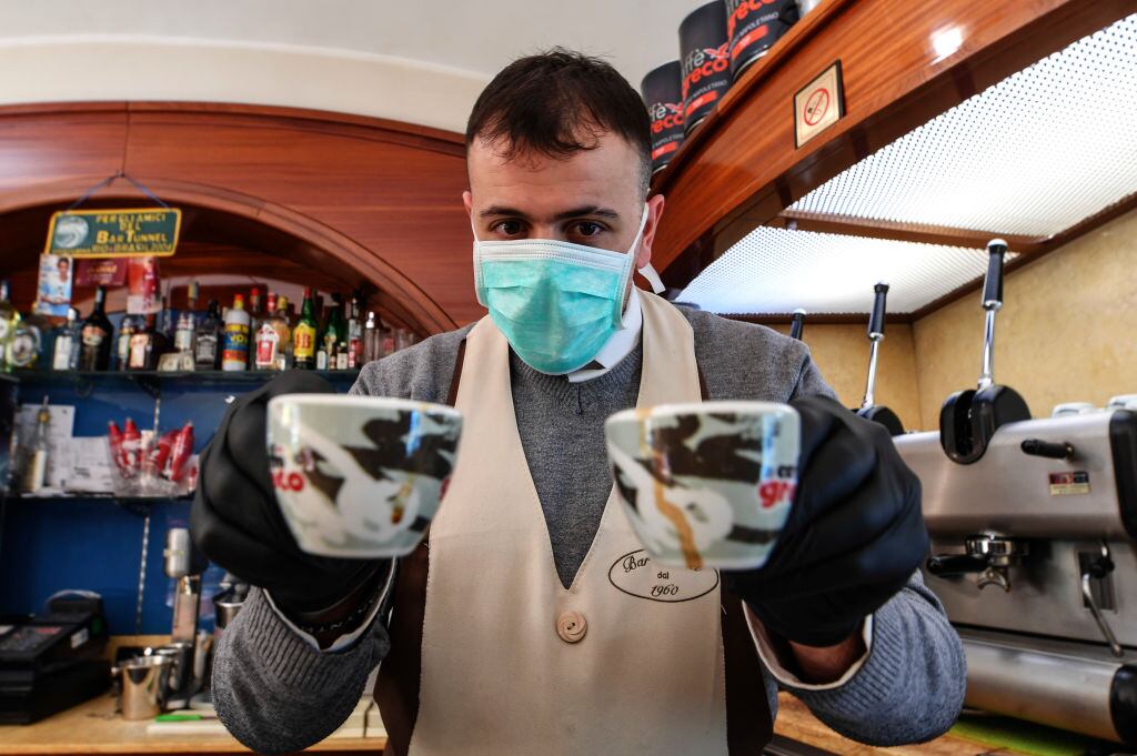 NAPLES, CAMPANIA, ITALY - 2020/03/10: A barista with a mask with two cups of coffee before 6 pm when the bars will be closed, as required by the latest government decree which, to avoid contagions from the coronavirus (COVID-19), has restricted the freedom of movement of people and has put all of Italy in a "protected area". (Photo by Salvatore Laporta/KONTROLAB/LightRocket via Getty Images)