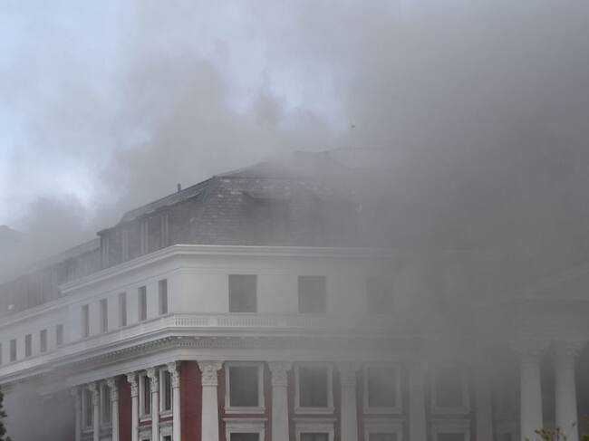 El humo cubre el cielo al salir de la sede del parlamento sudafricano