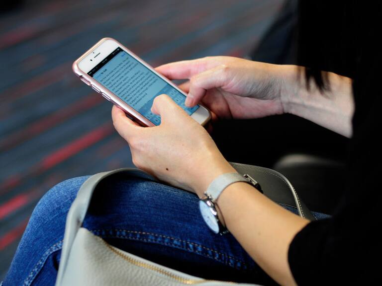 DALLAS, TX - SEPTEMBER 21, 2017: A woman uses her smartphone while waiting to board a plane at the Dallas/Fort Worth International Airport, located roughly halfway between Dallas and Fort Worth, Texas. (Photo by Robert Alexander/Getty Images)