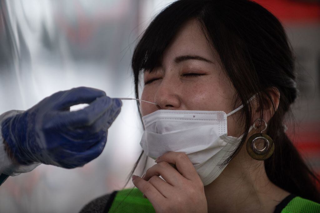 Un médico aplica el test del coronavirus a una mujer en Japón