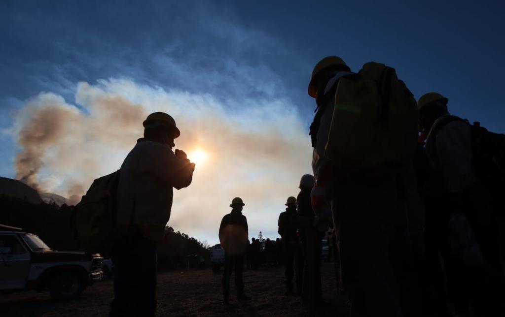 Voluntarios ven paso de helicóptero para combatir incendio forestal en México