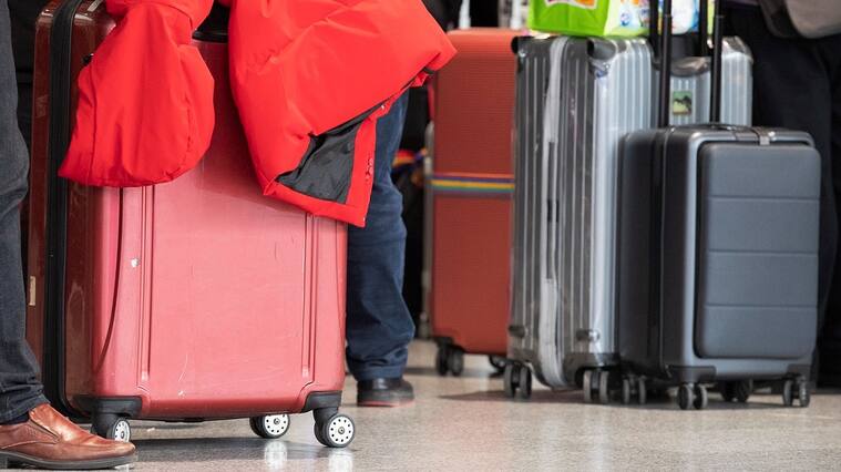 Un grupo de pasajeros llevan sus maletas en un aeropuerto