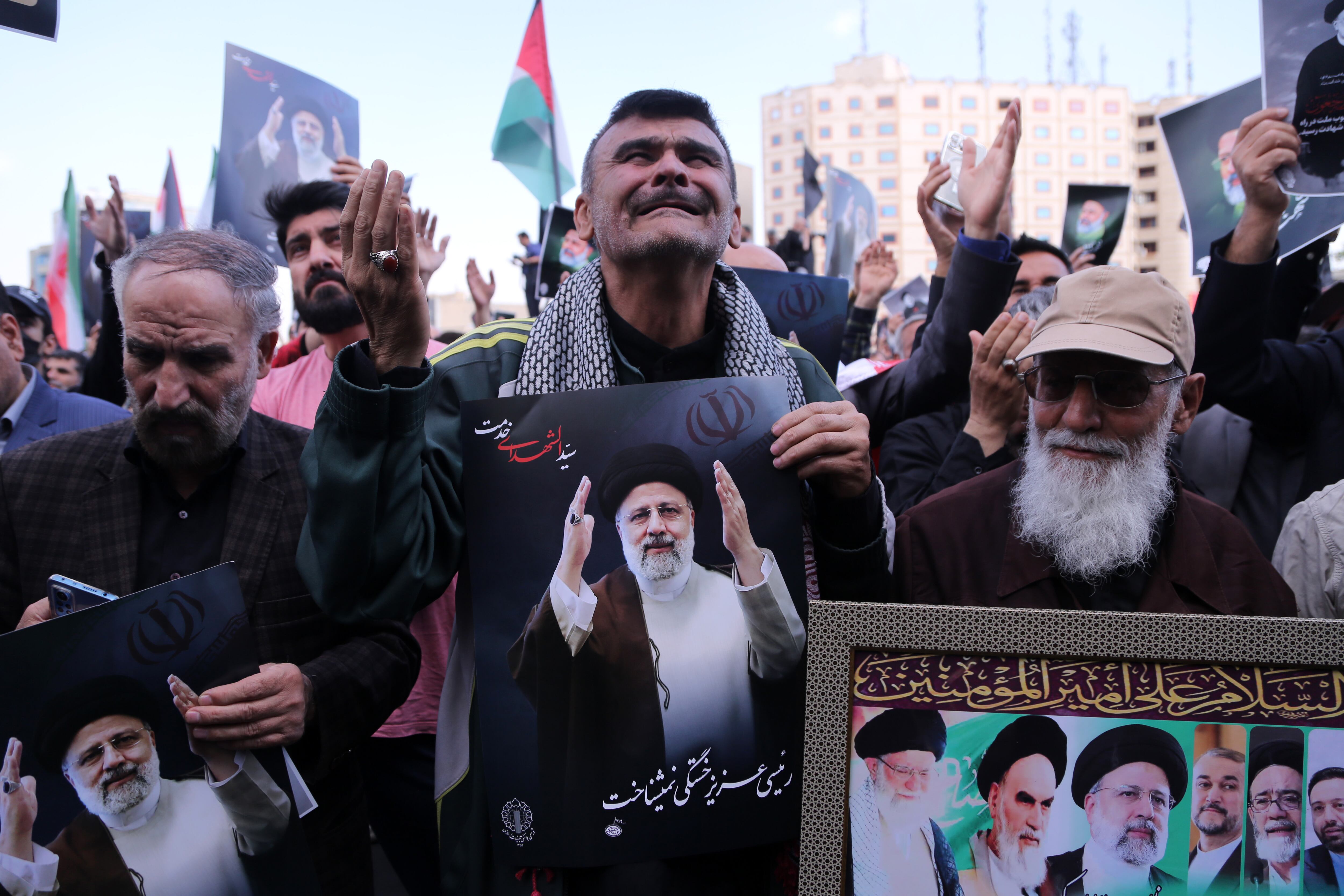 TEHRAN, IRAN - MAY 20: People holding photos gathering at Valiasr Square mourn the death of Iranian President Ebrahim Raisi, Foreign Minister Hussein Amir Abdollahian and other Iranian officials in a helicopter crash on Sunday in Iran, during a ceremony in Tehran on May 20, 2024. (Photo by Fatemeh Bahrami/Anadolu via Getty Images)