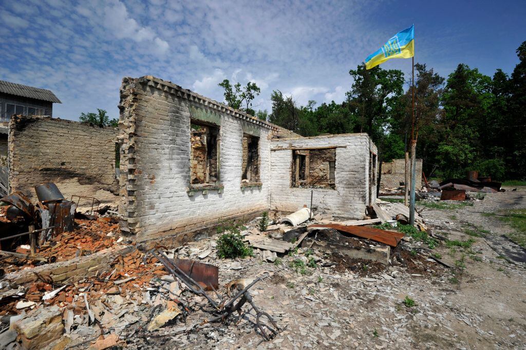 La bandera de Ucrania flamea ante la destrucción en la villa Moshchun
