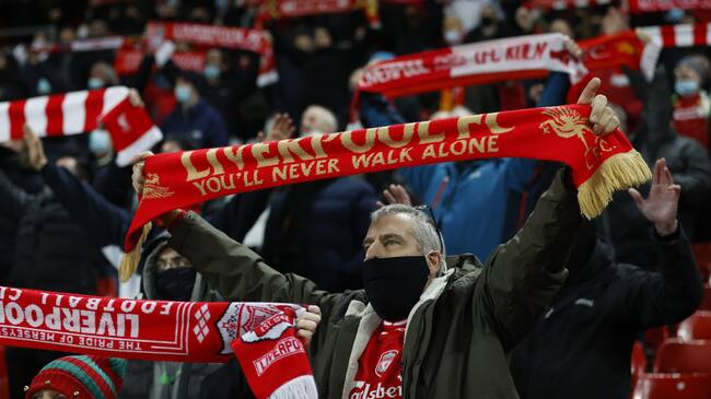 LIVERPOOL, ENGLAND - DECEMBER 16: Liverpool fans show their support as they observe social distancing measures in the stands prior to the Premier League match between Liverpool and Tottenham Hotspur at Anfield on December 16, 2020 in Liverpool, England. A limited number of fans (2000) are welcomed back to stadiums to watch elite football across England. This was following easing of restrictions on spectators in tiers one and two areas only. (Photo by Clive Brunskill/Getty Images)