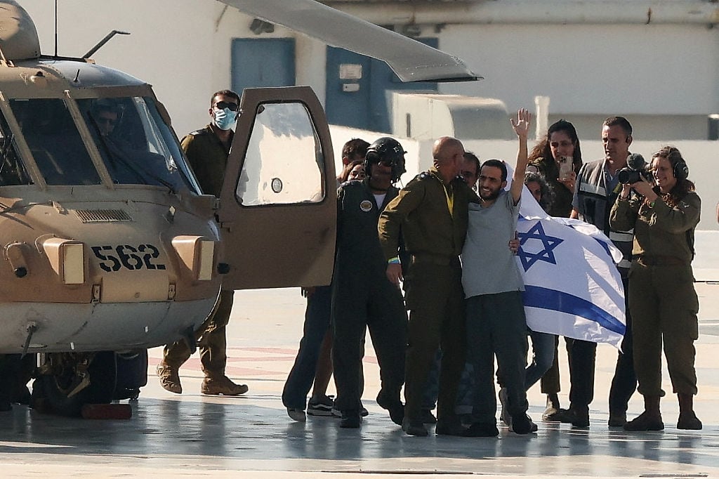 Former Israeli hostage Nimrod Cohen, who was held captive in Gaza since the 2023 October 7 attacks by Palestinian militants, waves upon disembarking from an Israeli military helicopter on the landing pad at Ichilov Sourasky Medical Centre in Tel Aviv on October 13, 2025. Twenty living Israeli hostages were released on October 13 after more than two years in captivity in Gaza, as part of a ceasefire deal with Hamas. Militants kidnapped them during Hamas's October 7, 2023 attack on Israel, the deadliest in the country's history. (Photo by Jack GUEZ / AFP) (Photo by JACK GUEZ/AFP via Getty Images)          