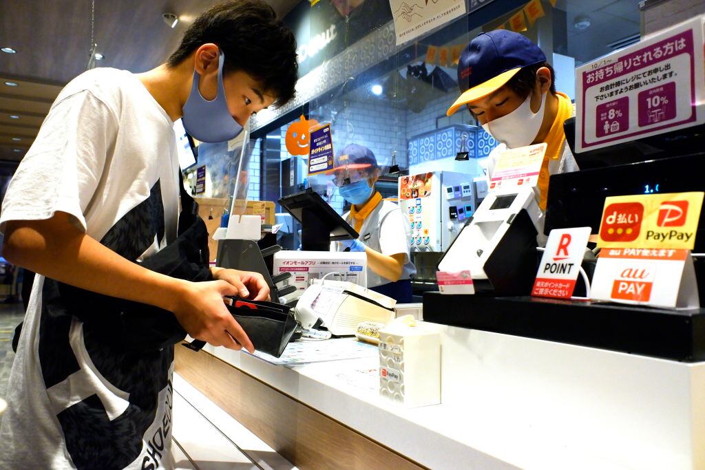 Personas usan mascarilla en una tienda en Tokio