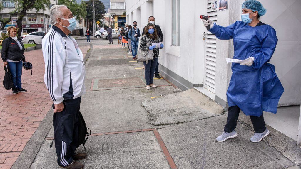 BOGOTA, COLOMBIA - MARCH 30: A staff member takes the temperature of a patient before entering a medical clinic on March 30, 2020 in Bogota, Colombia. Colombia started a national quarantine on March 25 until April 13 to control spread of COVID-19. The pandemic has spread to many countries across the world, claiming over 30,000 lives and infecting hundreds of thousands more. (Photo by Guillermo Legaria/Getty Images)