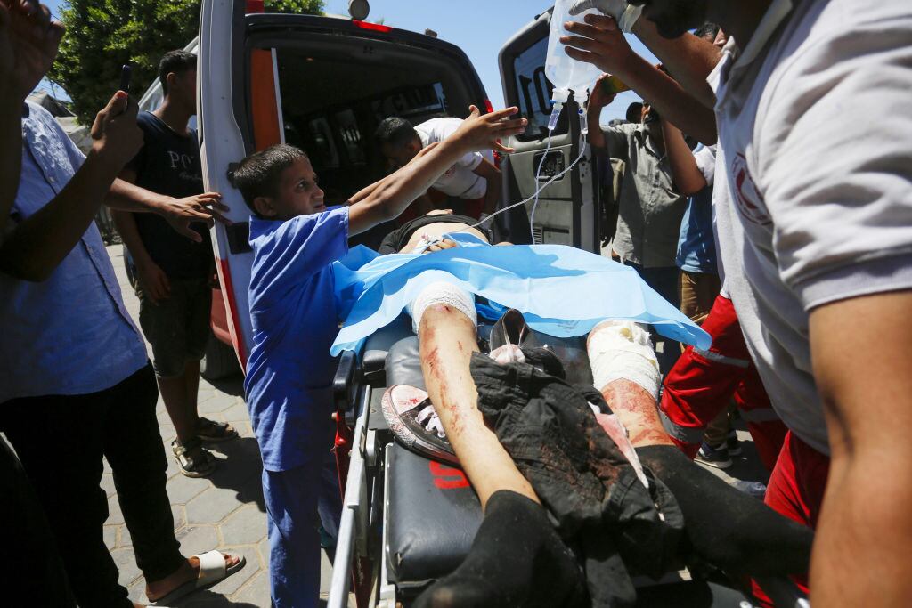 Personas palestinas son llevadas heridas a un hospital de la Franja de Gaza tras el ataque de Israel contra una escuela en Jan Yunis.