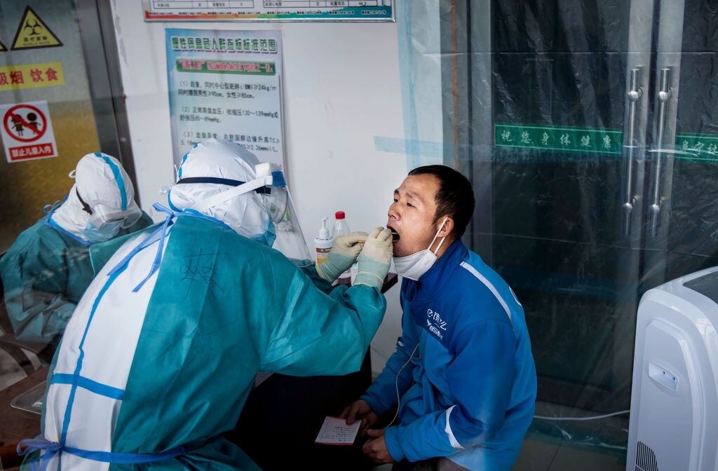 Médicos aplican un test del Covid-19 a un paciente en China