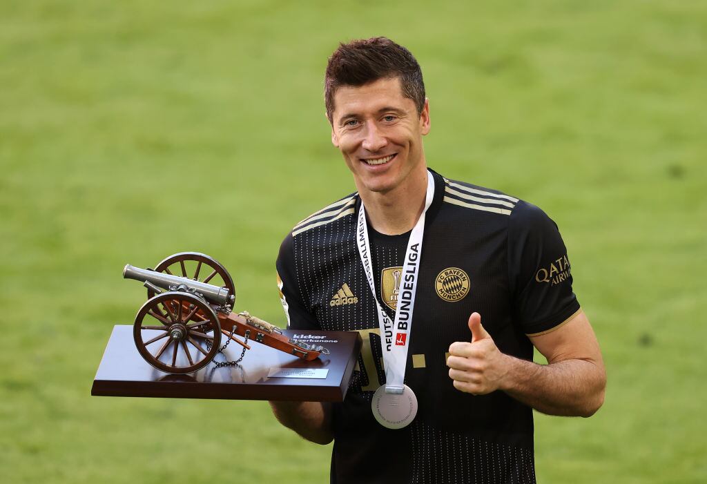 MUNICH, GERMANY - MAY 22: Robert Lewandowski of FC Bayern Muenchen raises the top goalscorer of the season award following the Bundesliga match between FC Bayern Muenchen and FC Augsburg at Allianz Arena on May 22, 2021 in Munich, Germany. After the Bavarian cabinet decided on first relaxations for outdoor events, the current Corona situation allows FC Bayern to have its last match of the season in front of 250 spectators in the Allianz Arena. Of these, 100 tickets are given to people from the health sector selected by the Ministry of Health. (Photo by Alexander Hassenstein/Getty Images)