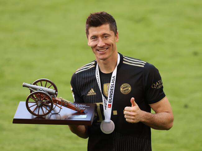 MUNICH, GERMANY - MAY 22: Robert Lewandowski of FC Bayern Muenchen raises the top goalscorer of the season award following the Bundesliga match between FC Bayern Muenchen and FC Augsburg at Allianz Arena on May 22, 2021 in Munich, Germany. After the Bavarian cabinet decided on first relaxations for outdoor events, the current Corona situation allows FC Bayern to have its last match of the season in front of 250 spectators in the Allianz Arena. Of these, 100 tickets are given to people from the health sector selected by the Ministry of Health. (Photo by Alexander Hassenstein/Getty Images)