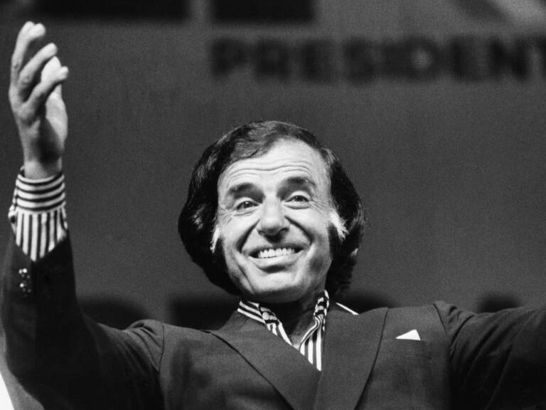 BUENOS AIRES, ARGENTINA - JULY 11: Argentine President Carlos Saul Menem greets with his arms raised during a Peronist political act in view of the legislative elections at Luna Park Stadium on July 11, 1991, in Buenos Aires, Argentina. (Photo by Ricardo Ceppi / Getty Images)