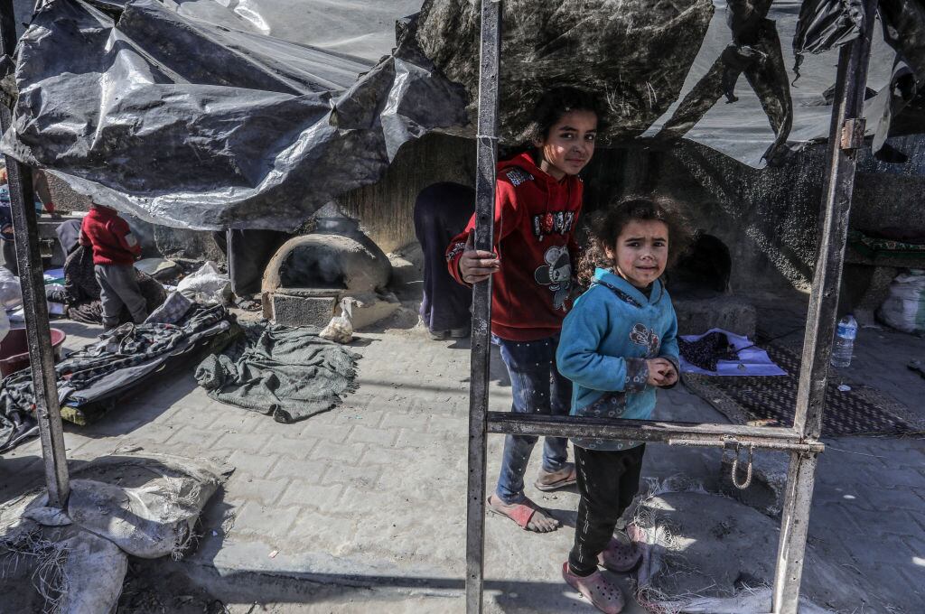 Dos niños palestinos en medio de un campamento de refugiados en la zona de Rafah de la Franja de Gaza, cerca de los ataques de Israel a ese enclave.