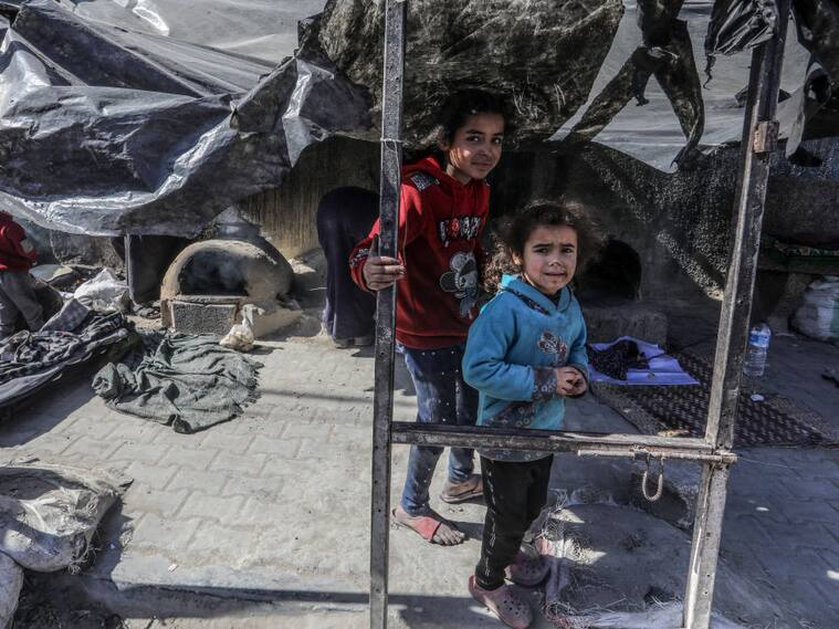 Dos niños palestinos en medio de un campamento de refugiados en la zona de Rafah de la Franja de Gaza, cerca de los ataques de Israel a ese enclave.