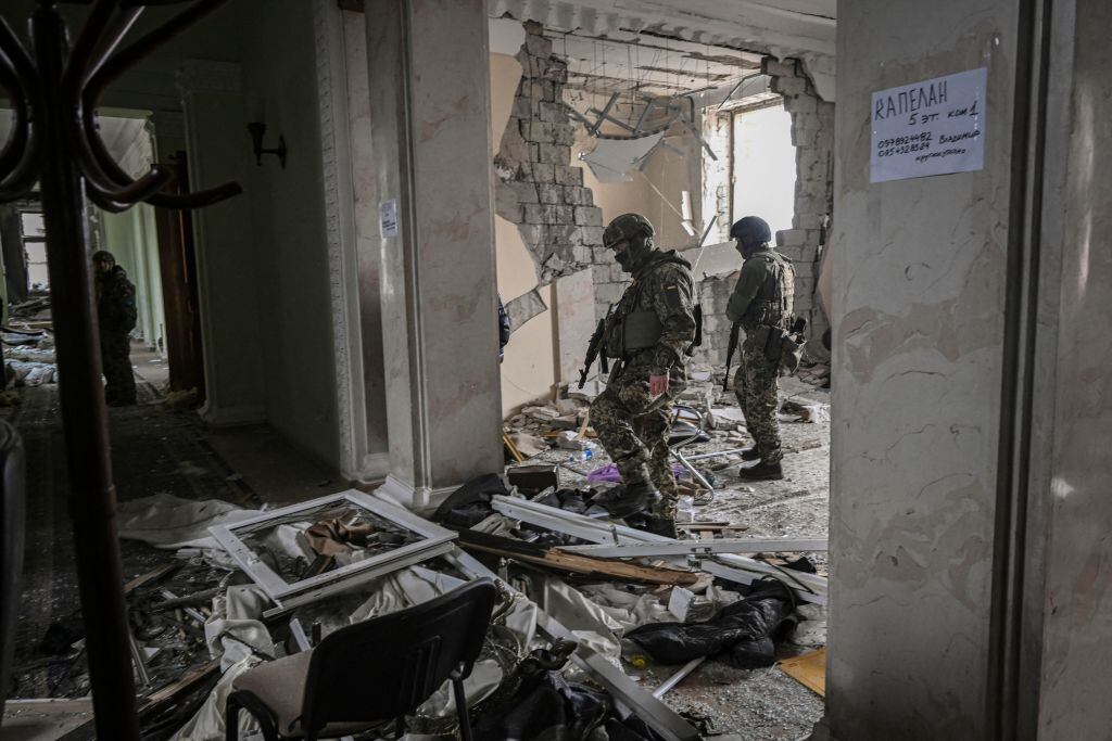 Soldados ucranianos revisan un edificio dañado en la guerra