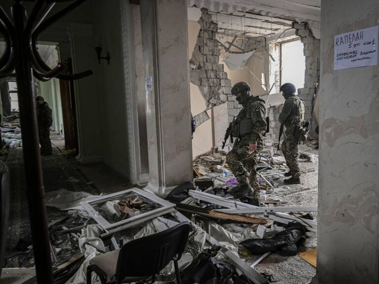 Soldados ucranianos revisan un edificio dañado en la guerra