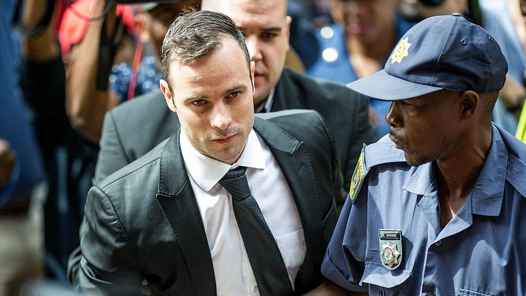 TOPSHOT - South African paralympian Oscar Pistorius (L) arrives to the Pretoria High court for a bail hearing on December 8, 2015.Pistorius appeared in court for a bail hearing that could put him back in prison after he was convicted of his girlfriend's murder on appeal. South African appeal judges last week found him guilty of murder and overturned his earlier conviction on the lesser charge of culpable homicide for shooting dead Reeva Steenkamp in 2013. / AFP / MUJAHID SAFODIEN        (Photo credit should read MUJAHID SAFODIEN/AFP via Getty Images)