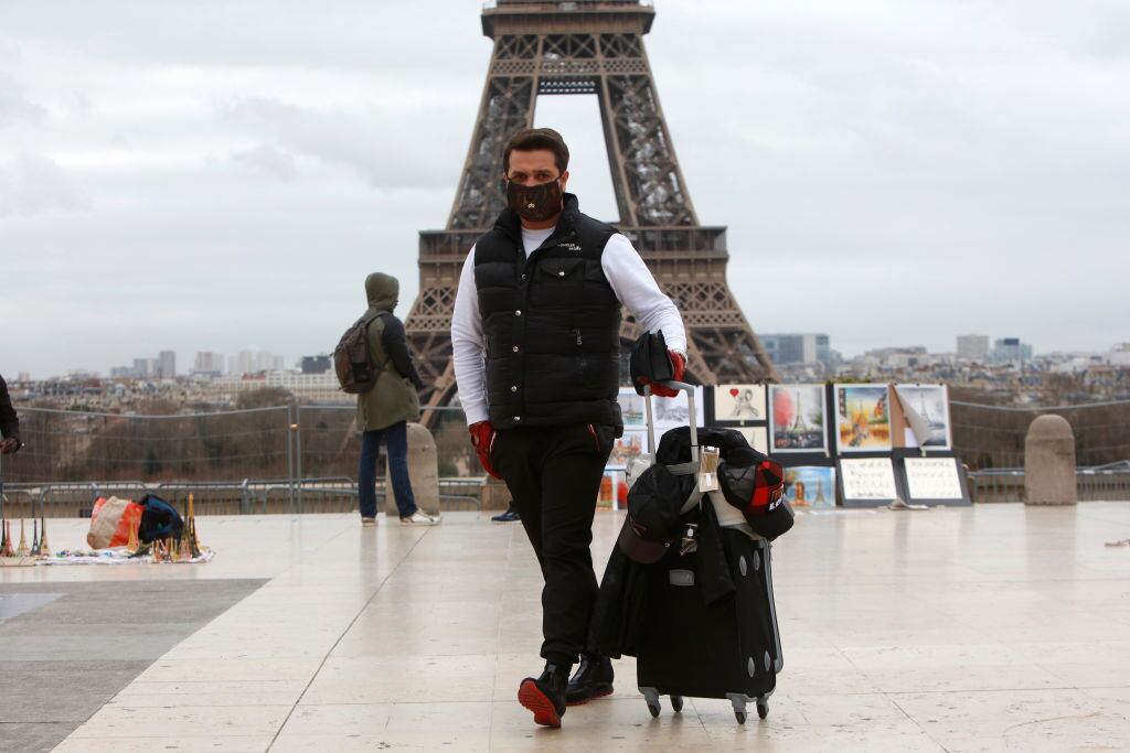 Un hombre se protege con una máscara en los alrededores de la Torre Eiffel en París