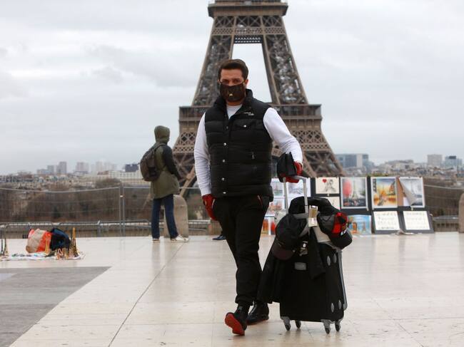 Un hombre se protege con una máscara en los alrededores de la Torre Eiffel en París