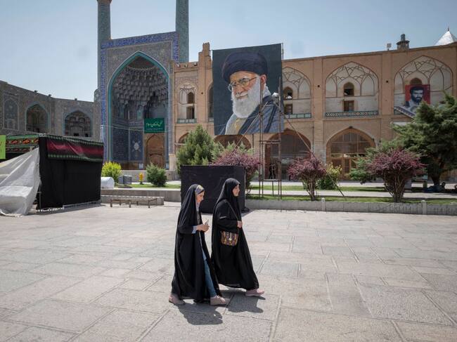 Dos mujeres caminan frente a una mezquita en la ciudad iraní de Isfahán.