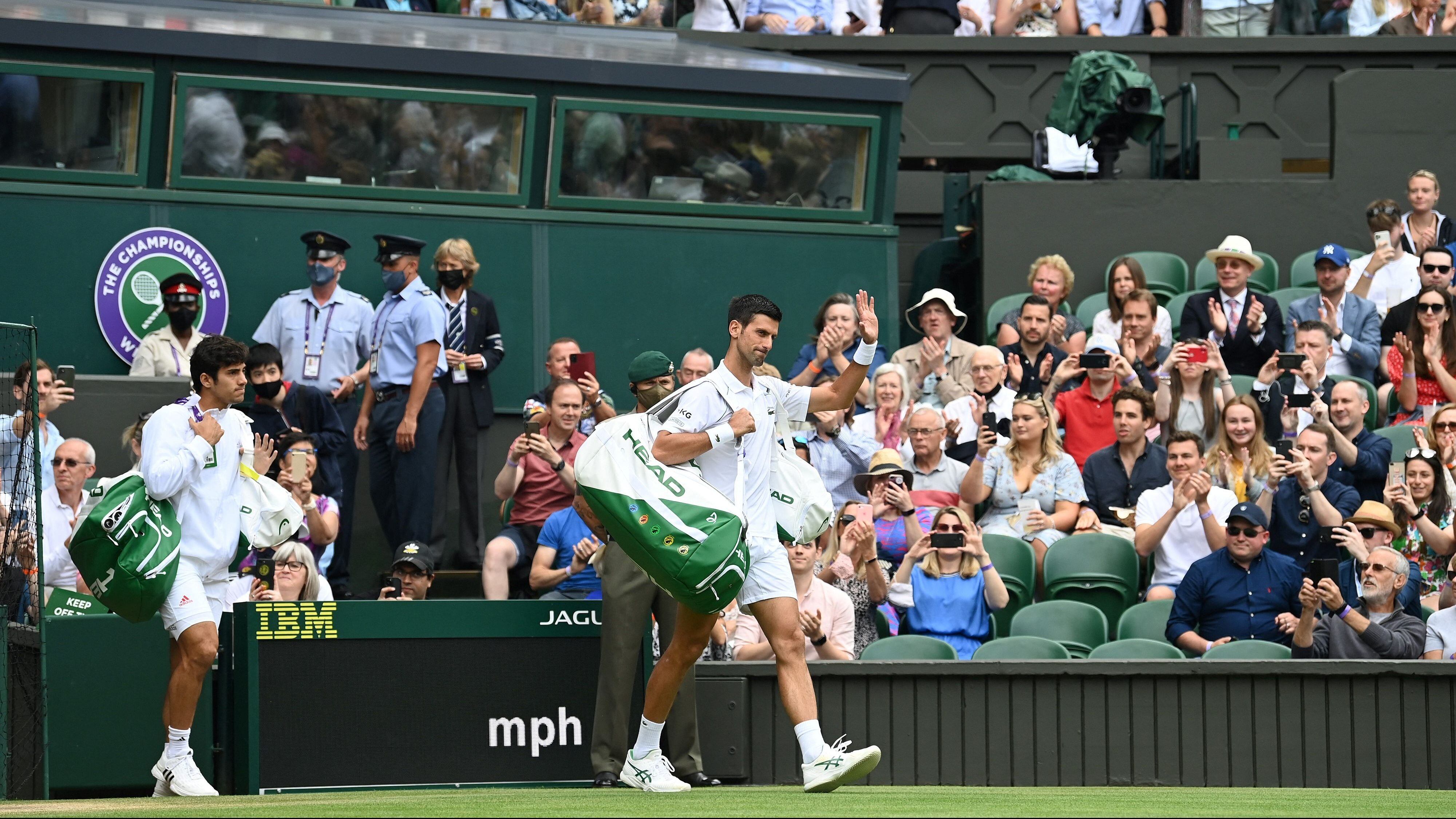 Chile's Cristian Garin (L) and Serbia's Novak Djokovic arrive on court for their men's singles fourth round match on the seventh day of the 2021 Wimbledon Championships at The All England Tennis Club in Wimbledon, southwest London, on July 5, 2021. - RESTRICTED TO EDITORIAL USE (Photo by Glyn KIRK / AFP) / RESTRICTED TO EDITORIAL USE (Photo by GLYN KIRK/AFP via Getty Images)