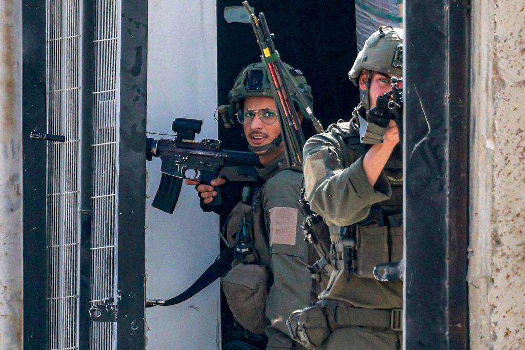 Soldados de Israel apuntan sus armas en contra de ciudadanos palestinos en el territorio de Cisjordania en Palestina.