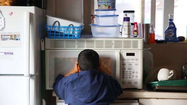 Ali Alhamdan, 10, peers into the microwave as he waits for a bag of popcorn to pop, Feb. 16, 2017. (Genna Martin, seattlepi.com) (Photo by GENNA MARTIN/San Francisco Chronicle via Getty Images)