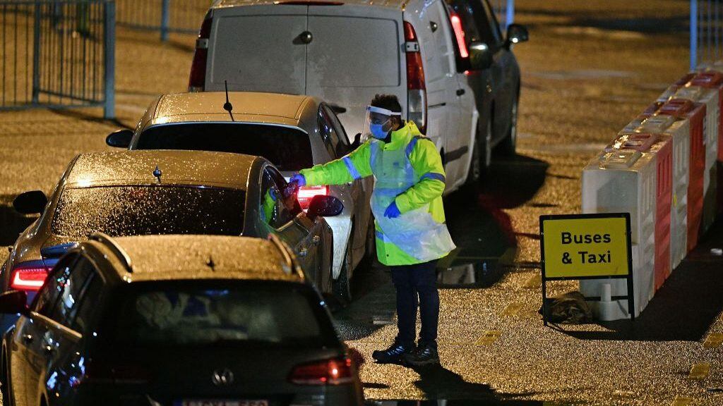 A Test and Trace worker wearing PPE talks to drivers at the Port of Dover, in Dover in Kent, south east England, on December 23, 2020, as the COVID-19 testing of drivers queueing to depart from the ferry terminal to Europe gets underway. - France and Britain reopened cross-Channel travel on Wednesday after a 48-hour ban to curb the spread of a new coronavirus variant but London has warned it could take days for thousands of trucks blocked around the port of Dover to get moving. (Photo by JUSTIN TALLIS / AFP) (Photo by JUSTIN TALLIS/AFP via Getty Images)