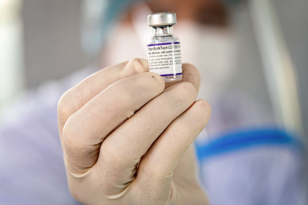 Personal médico tiene una dosis de una vacuna contra el covid-19 de Pfizer