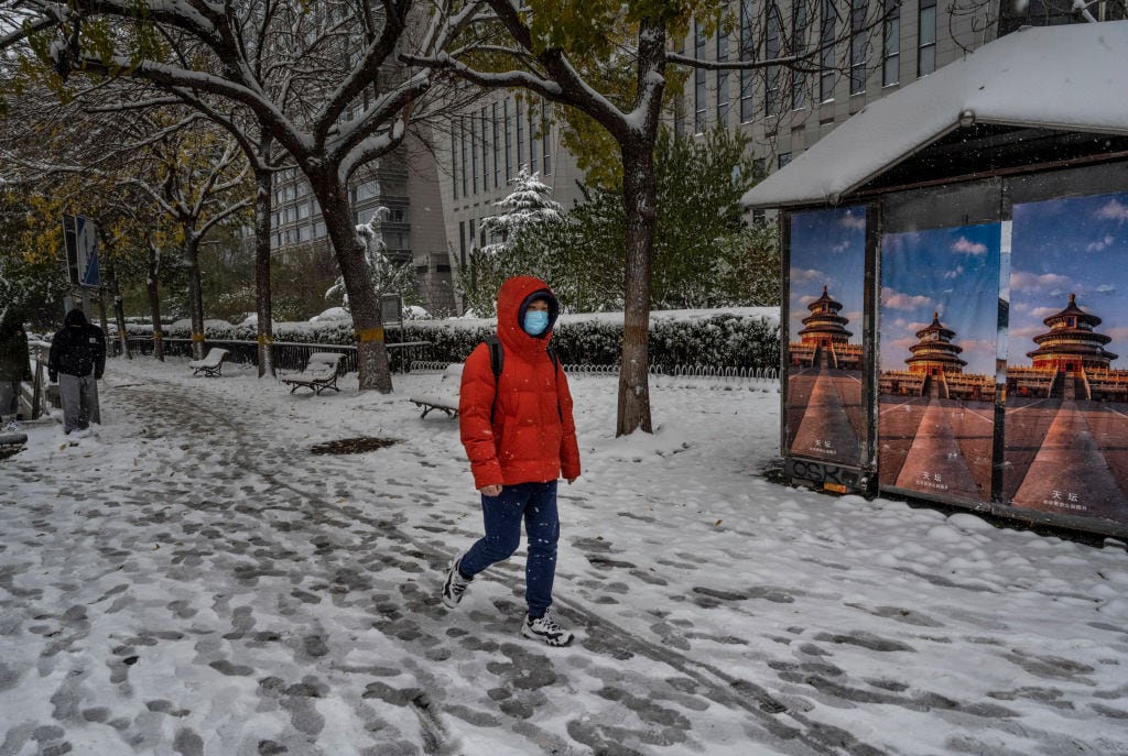 Persona camina por la nieve que hay en las calles de Beijing