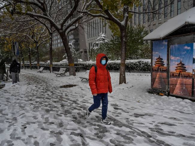 Persona camina por la nieve que hay en las calles de Beijing